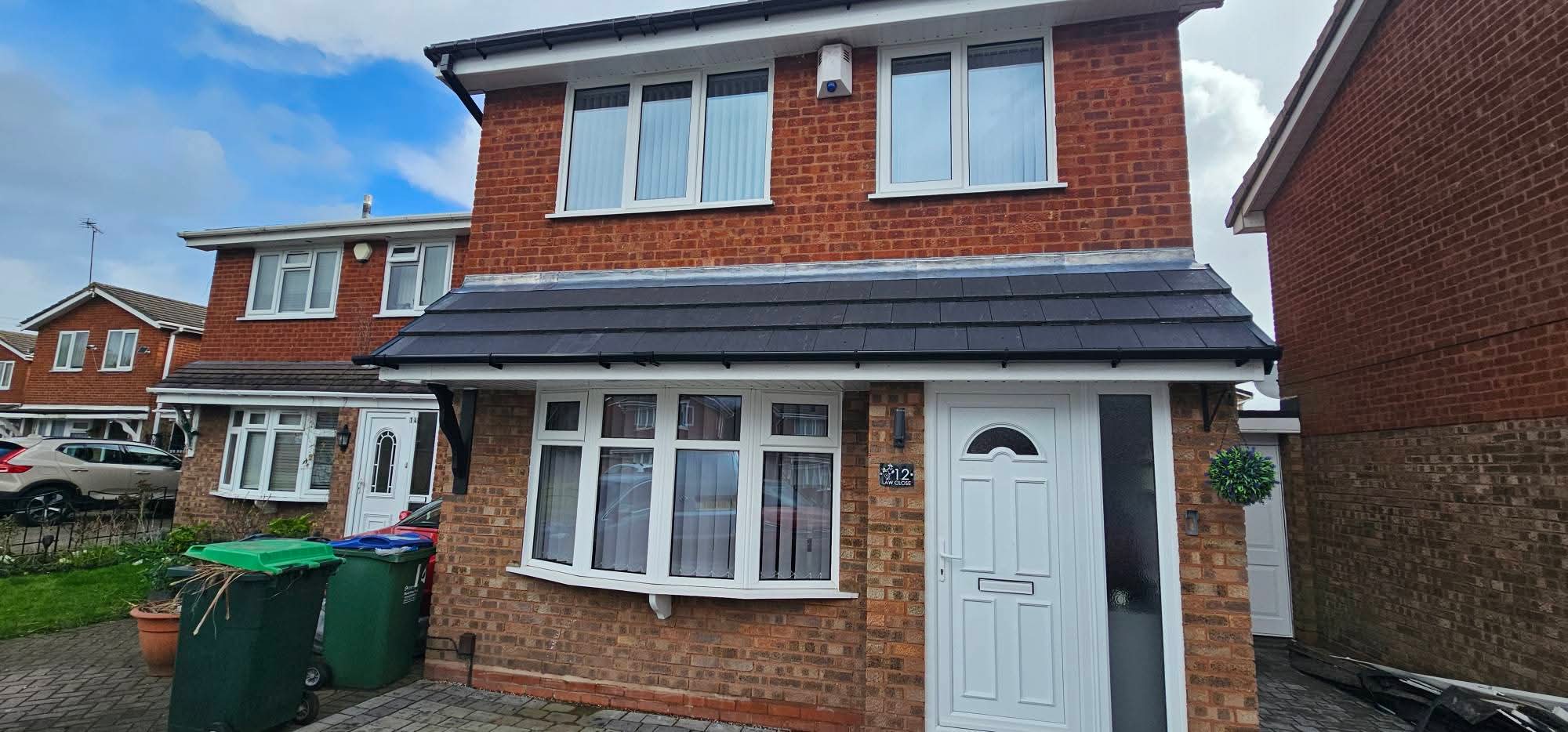 New dark tiled porch roof with white roofline trim on a brick house